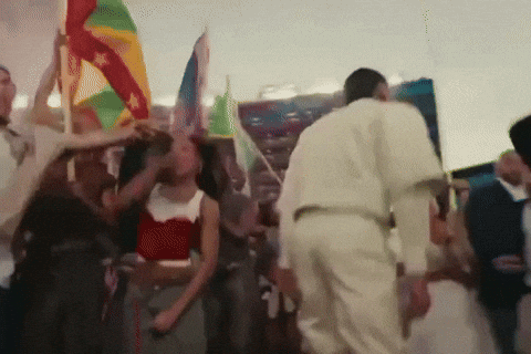 Bad Bunny dancing at Superbowl halftime show with flags of the Americas.